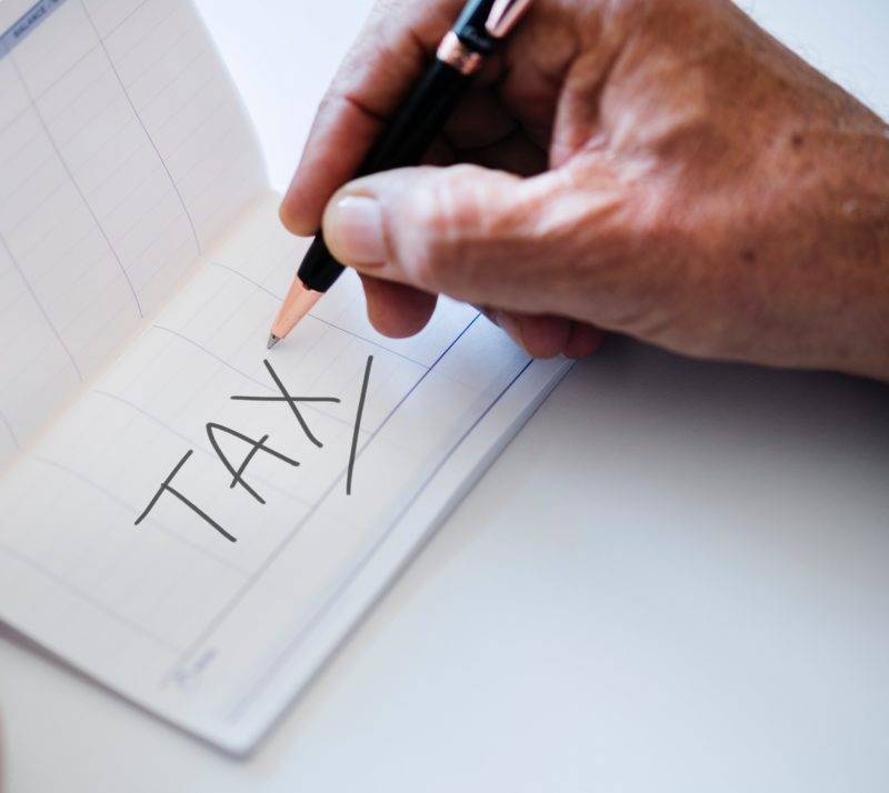 Piece of paper with the word tax written on it.