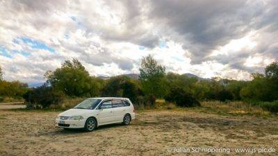 Minivan auf sandigem Platz in der Natur