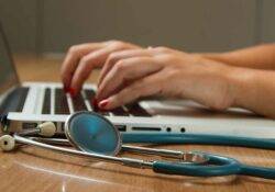 Immigration Medical Arzt sitzt am Laptop