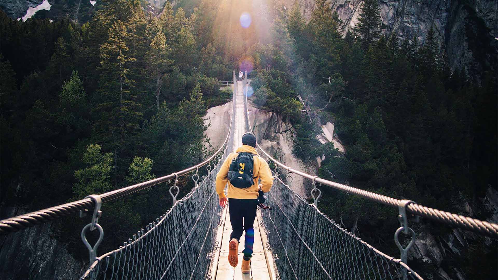 Backpacker überquert eine Hängebrücke